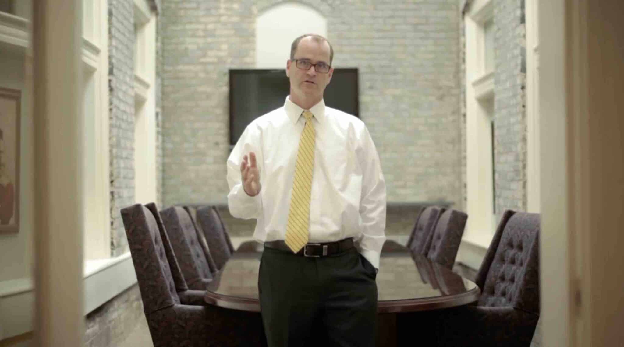 A photo of attorney David C. Hardy speaking in his conference room.